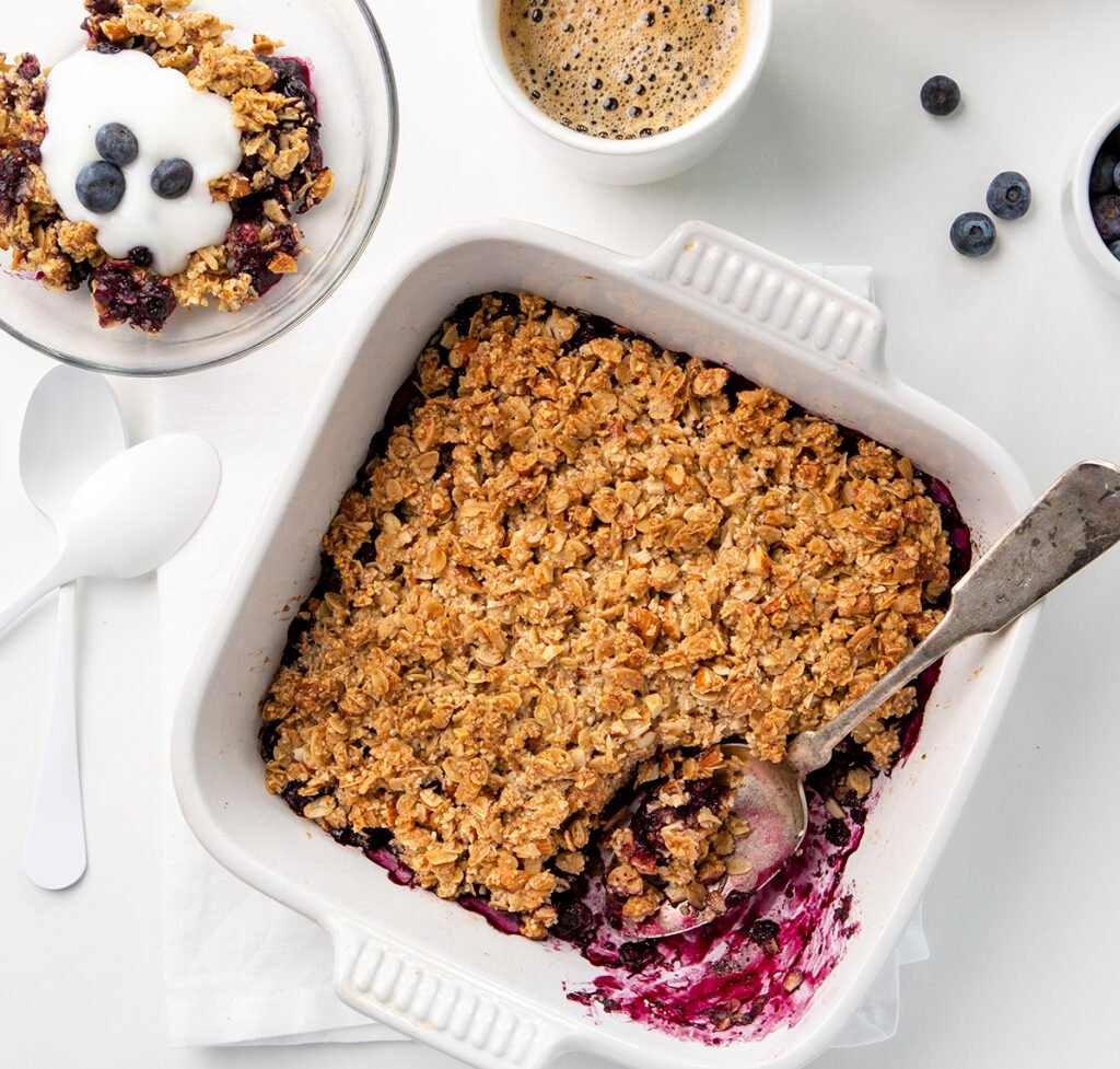 Blueberry Breakfast Crisp with a spoon in the white baking dish, along side of a bowl of breakfast crisp and a cup of coffee. Blueberry Crisp, Easy Blueberry Crisp, Healthy Blueberry Crisp, Healthy Food, Real Food, Real Food Recipes, Healthy Food Recipes, Wholesome food, Wholesome food recipes, Whole Food, Whole Food Recipes, Realgood food, Realfooddaily Eat real, Good Real Food, Goodrealfood,