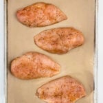 Seasoned and uncooked Oven Roasted Chicken breasts on a baking sheet with parchment. Healthy Food, Real Food, Real Food Recipes, Healthy Food Recipes, Wholesome food, Wholesome food recipes, Whole Food, Whole Food Recipes, Realgood food, Realfooddaily Eat real, Good Real Food, Goodrealfood, chicken, baked chicken, roasted chicken, oven roasted chicken, healthy chicken, easy chicken breasts, how to cook chicken, how to bake chicken, how to cook chicken in the oven, easy chicken recipes
