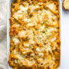 A baking dish filled with baked ziti, near a serving napkin, extra parsley, and shredded parmesan cheese. Healthy Food, Real Food, Real Food Recipes, Healthy Food Recipes, Wholesome food, Wholesome food recipes, Whole Food, Whole Food Recipes, Realgood food, Realfooddaily Eat real, Good Real Food, Goodrealfood, baked ziti, pasta, ground beef, casserole, baked ziti pasta, baked noodles, marinara sauce, easy baked dinners, ziti noodle
