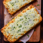 Cheesy Garlic Bread overhead on a cutting board with parchment paper.