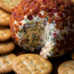 A jalapeno popper cheese ball, surrounded by crackers, with a few bites out of the cheese ball.