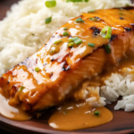 Bang Bang Salmon served over rice on a wooden plate.