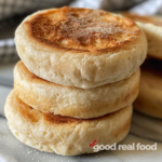 A stack of homemade sourdough English muffins.