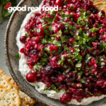 A bowl of cranberry salsa, served over cream cheese with buttery crackers.