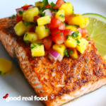 Chili lime salmon on a plate topped with pineapple salsa.