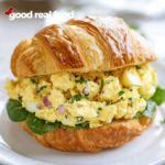 Egg salad sandwich on a white plate.