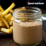 A mason jar filled with fry sauce, french fries in the background.