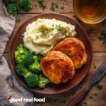 A plate of baked pork chops, served with mashed potatoes and broccoli.