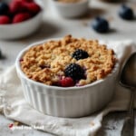 a ramekin filled with a fresh berry cobbler.