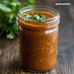 A jar filled with homemade enchilada sauce.