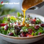 Greek Vinaigrette being poured over a salad.