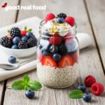A mason jar filled with overnight oats, topped with fruit, yogurt, and honey.