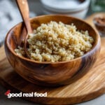 A wooden bowl filled with fluffy quinoa.