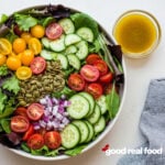 overhead image of a side salad with a vinaigrette dressing in a small bowl.