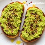 Two slices of avocado toast on a plate.