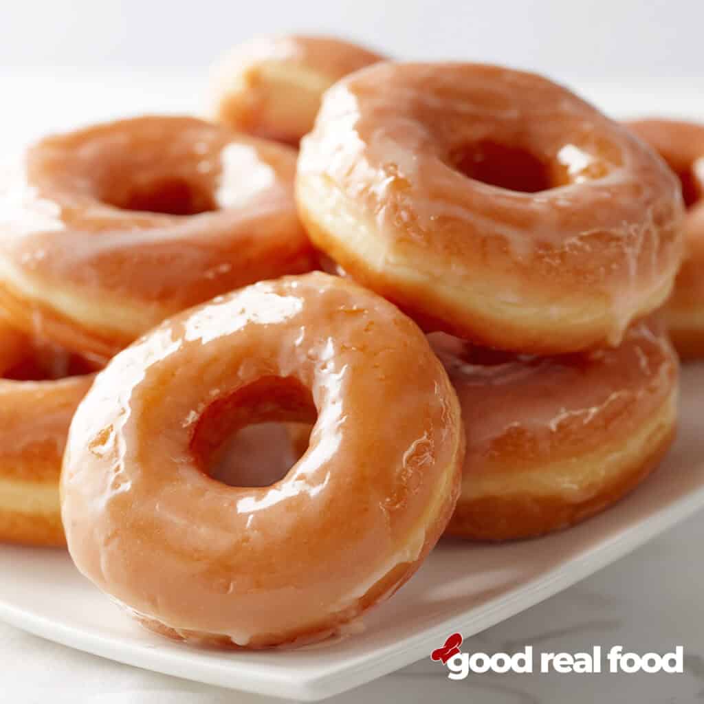 glazed donuts on a white platter.