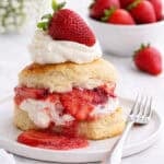 A strawberry shortcake on a white plate.