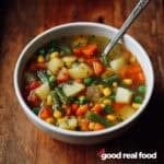 a white bowl of vegetable soup.
