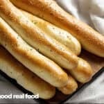 an overhead view of breadsticks on a wooden board.