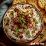 A bowl of crack dip with crackers.