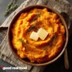 Mashed Sweet Potatoes topped with butter and thyme.