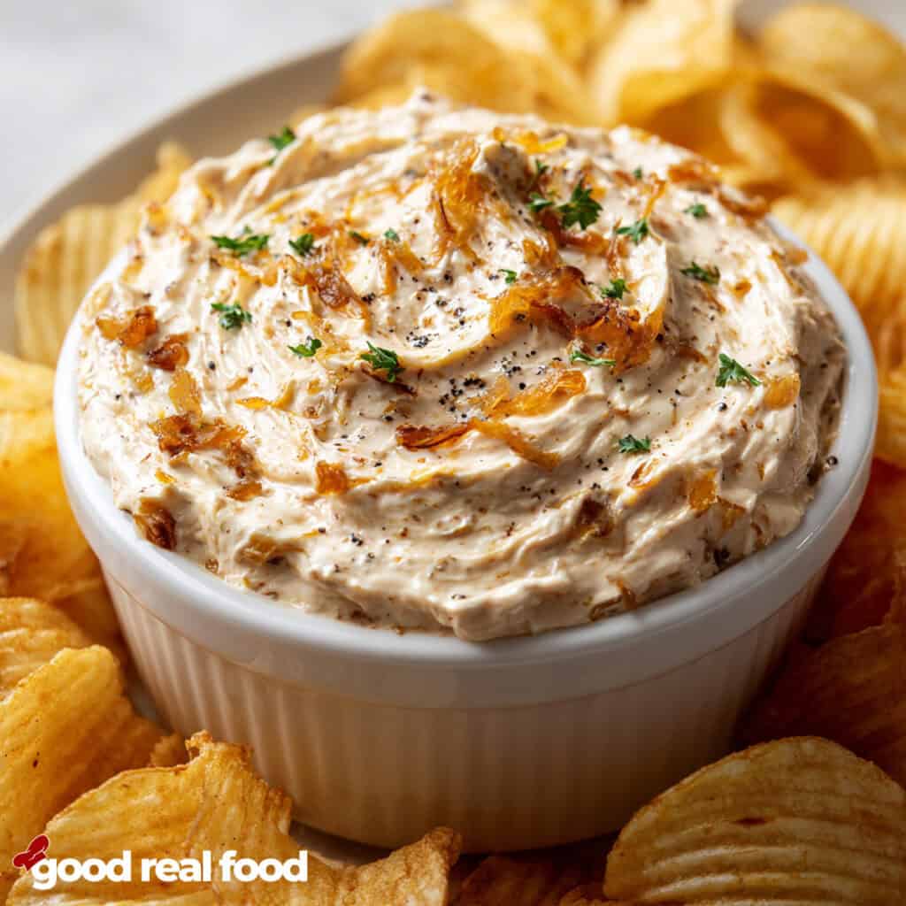 French Onion Dip in a white bowl surrounded by potato chips.