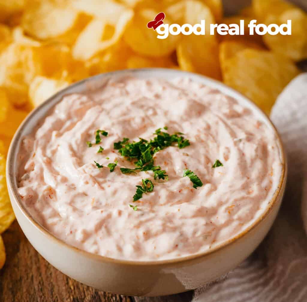 A bowl of boat dip surrounded by potato chip.