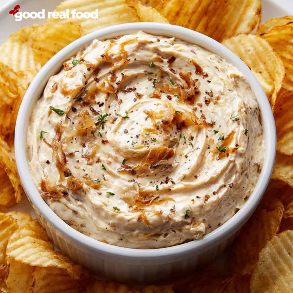 French Onion Dip in a white bowl surrounded by potato chips.