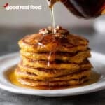 A stack of sweet potato pancakes drizzled with maple syrup.