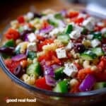 a glass bowl of Greek pasta salad.