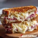 A Reuben sandwich on a wooden cutting board.