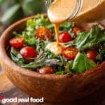 A salad being topped with Thousand Island dressing.