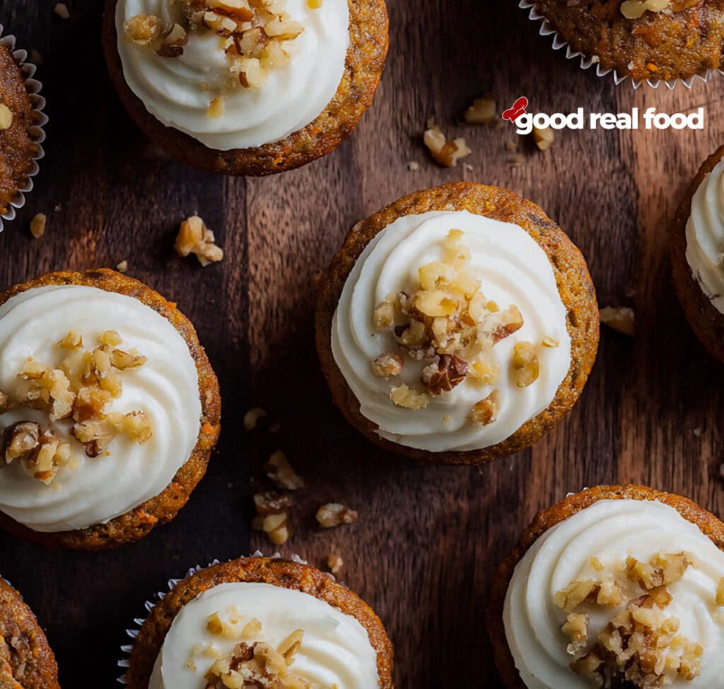An overhead image of carrot cake cupcakes on a wooden surface.