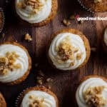 An overhead image of carrot cake cupcakes on a wooden surface.
