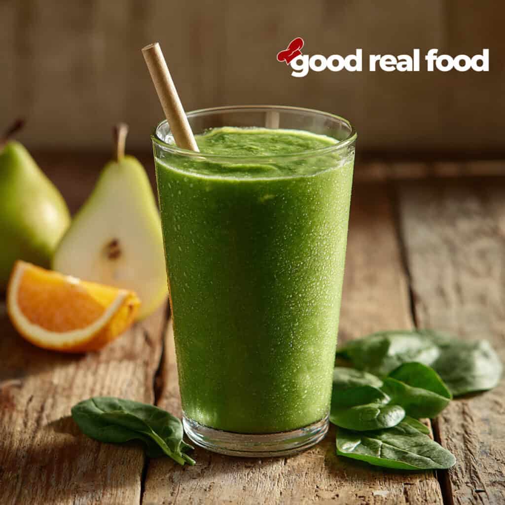 Green Smoothie with oranges and pears and a straw.