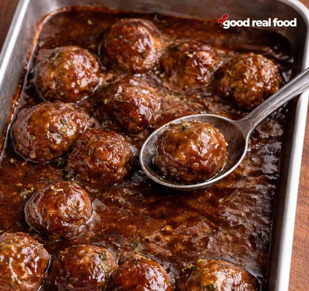 Honey BBQ Meatballs with a serving spoon lifting out a meatball.