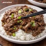 A plate of mongolian beef served over rice.