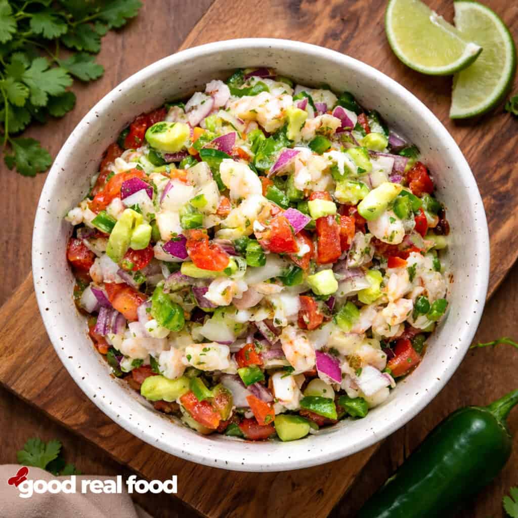A bowl of Shrimp Ceviche with limes.