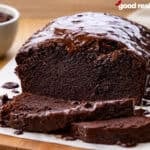 A loaf of brownie bread drizzled with chocolate and partially sliced.