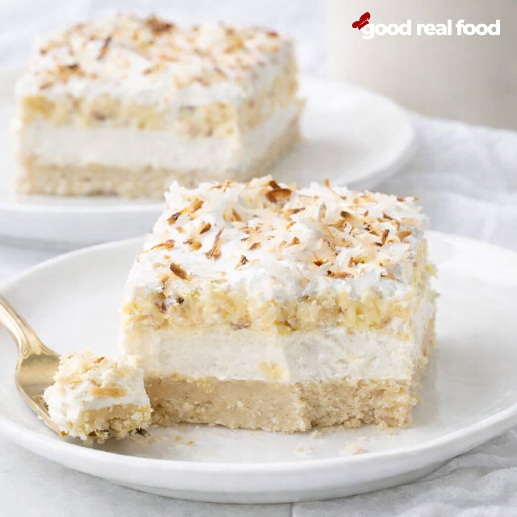 Coconut Cream Pie Bars on a white plate with a bite taken out.