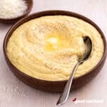 A brown bowl filled with creamy polenta.