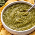 A bowl of salsa verde with tortilla chips.