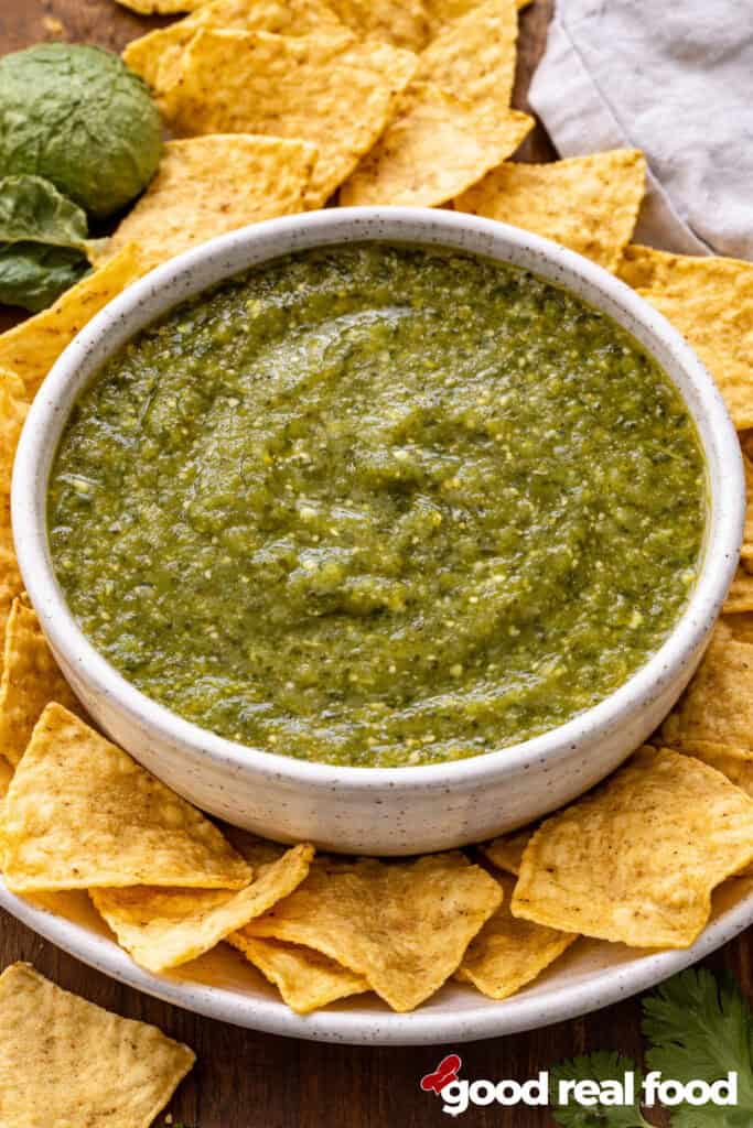 A bowl of salsa verde with tortilla chips.