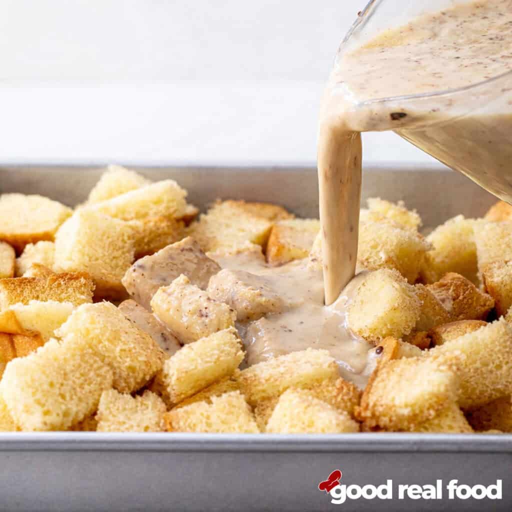 Overnight French Toast custard pouring over bread cubes.