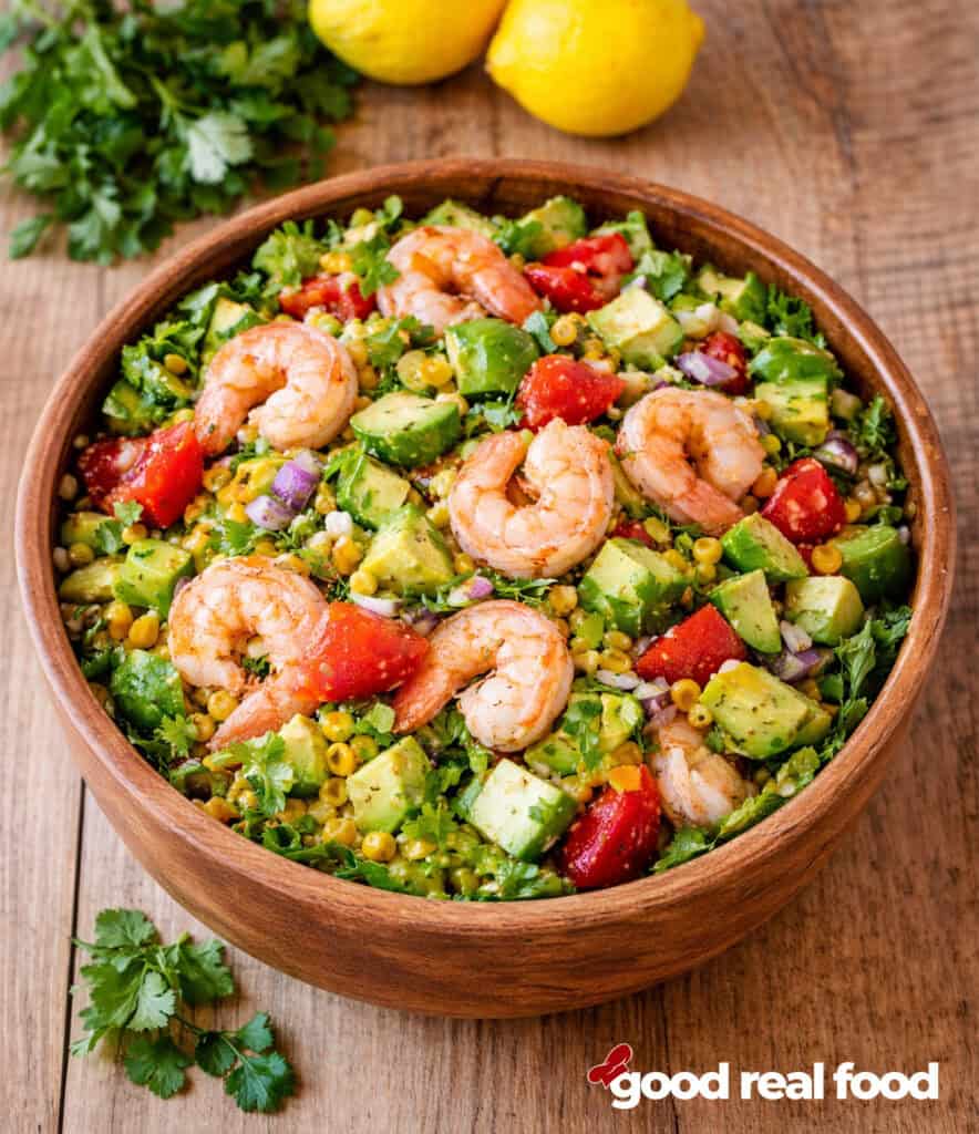 Shrimp and avocado salad in a wooden bowl.