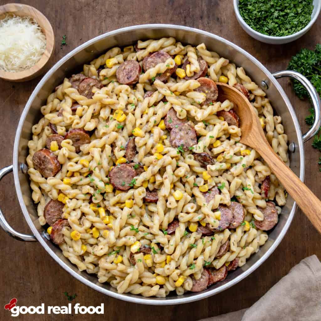 creamy cajun sausage pasta in a pan with a spoon.