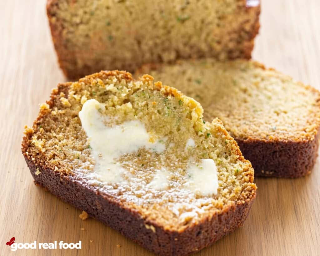 sliced zucchini bread with butter Sliced zucchini bread with butter on a wood counter