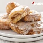 a pile of Mini Apple Pies on a stack of two white plates on a white cloth